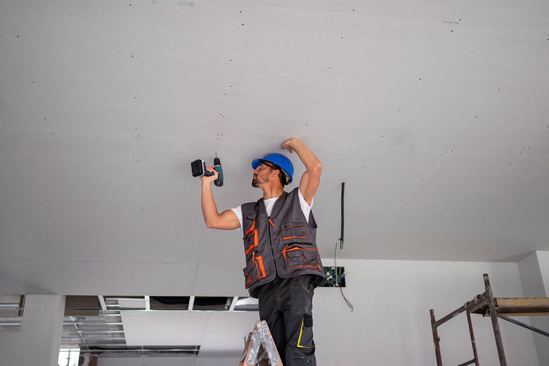 How Much Does Drywall Repair Cost in Eugene, OR? 3 medium shot man standing ladder
